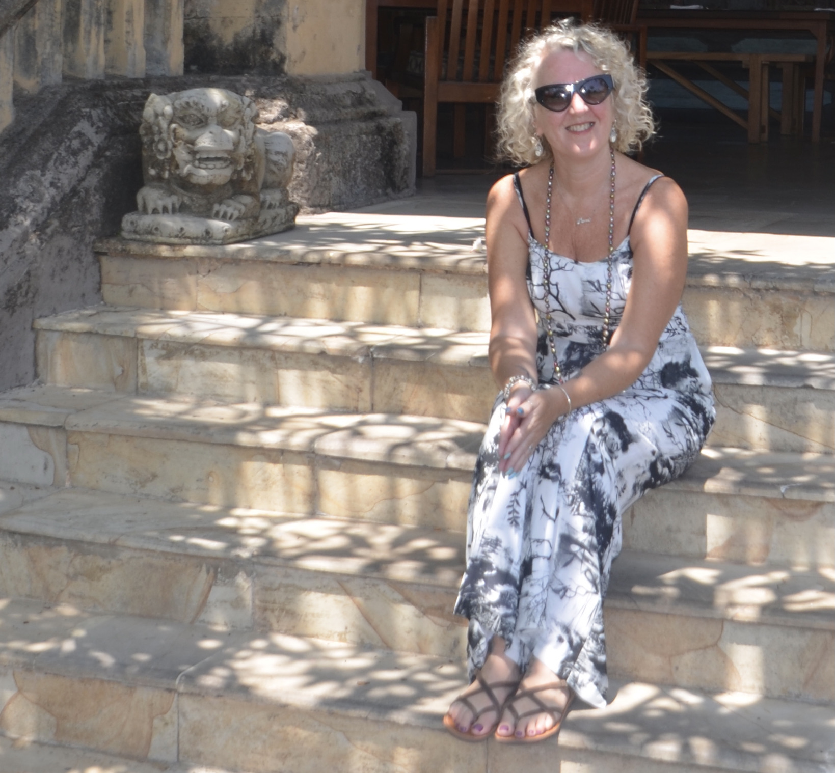 Christie Adams sitting on steps in the sunshine at a Bali resort